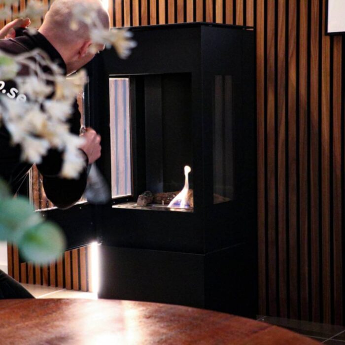 Etanolkamin Apartment Allerum Svart placerad mot vägg med dörr på glänt